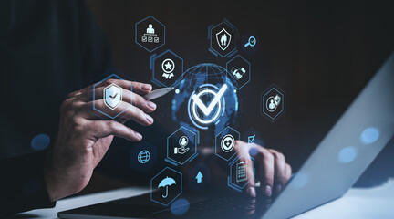 Businessman's hands interacting with digital hologram of security and compliance icons over laptop, representing data protection and technology concept.