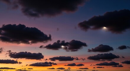 Fototapeta premium Dramatic clouds form a colorful sunset sky with vibrant orange and purple hues.