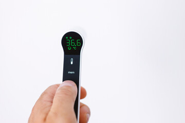 Infrared digital thermometer in hand on white background, modern smart healthcare device for measuring body temperature.