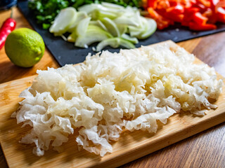 Cut snow mushrooms on cutting board on wooden table