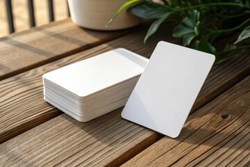 Blank Playing Cards on a Wooden Table Surrounded by Green Plants