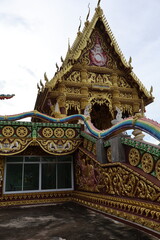 A traditional Thai temple, resplendent in its ornate architecture. The temple's roof is adorned with intricate designs and golden accents, reflecting the rich cultural heritage of Thailand