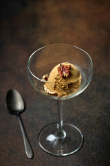 caramel ice cream scoop with nut  in glass bowl