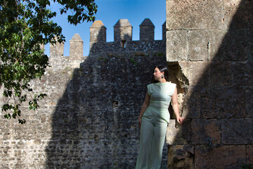 A beautiful Latin teenager with long dark hair poses on the stones of an abandoned castle on the outskirts of the city. The woman strikes different poses and expressions.