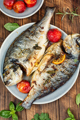 Baked dorado fish with plums served on a plate.