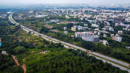 Fototapeta premium Arial shot of Beautiful road infrastructure of karnataka in India. Aerial view city traffic Highway road with car vehicle movement in Bangalore.