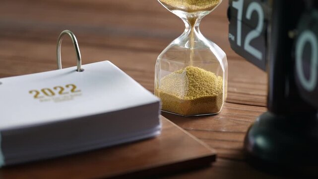 Time passing concept with hourglass and 2022 calendar showing year transition and deadline management