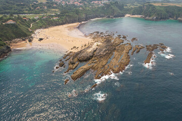 Aerial view of Amio Beach and Pechon village on sunny day. Cantabria, Spain.