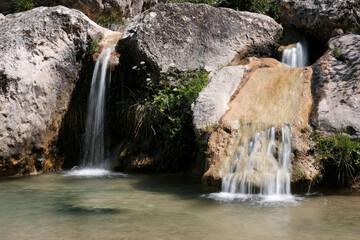 Long exposure shot of small waterfalls in Gorg Gorge (Barranc del Gorg) on sunny summer day. La Febr&oacute;, Tarragona, Spain.
