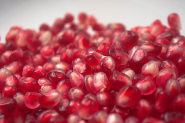 Many red pomegranate seeds on white background