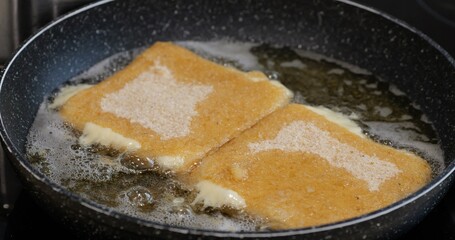 Fried dough covered in sugar. Close-up view of the golden-brown food, likely a snack or dessert, prepared in a kitchen setting: Plze?, Czech - Oct,11,2025