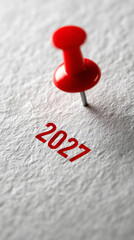 Red pin marks year 2027 on white paper
