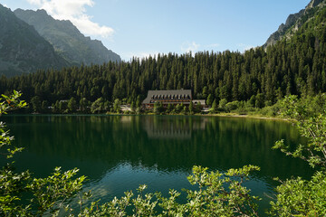 Popradske Pleso, beautiful glacial lake in High Tatras and mountain hut mirroring, popular hiking trail in Slovakia
