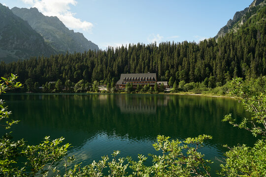 Popradske Pleso, beautiful glacial lake in High Tatras and mountain hut mirroring, popular hiking trail in Slovakia - Powered by Adobe