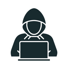 Silhouette of a hooded hacker working on a laptop in a dark environment 
