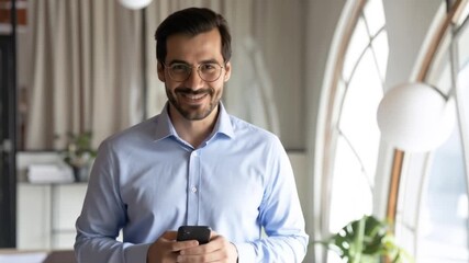 Confident Businessman Smiling with Holding Smartphone, Office Interior, and Daylight  Success. - Powered by Adobe