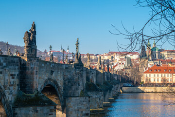 Scenic view of Prague's iconic Charles Bridge with its historic arches and Baroque statues, overlooking the Vltava River and Lesser Town. Prague, Czech Republic - February 18, 2025