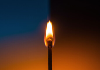 Solitary Burning Matchstick with a Bright Flame on a Gradient Background