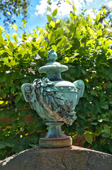 schöne Urne mit Deckel aus Metall auf einem Grabstein  auf einem Münchner Friedhof © Blende8