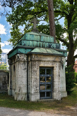 sehr altes Mausoleum mit grünem Dach und schöner Türe  auf einem Münchner Friedhof © Blende8