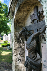 schöne Seitenansicht eines Grabsteins mit dem gekreuzigten  auf einem Münchner Friedhof © Blende8