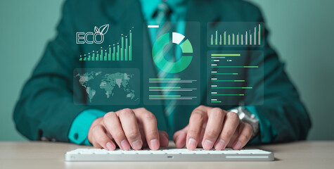 A businessman typing on a keyboard with eco data graphics, symbolizing carbon footprint tracking, green sustainability, carbon credits, and climate change awareness in modern environmental business.