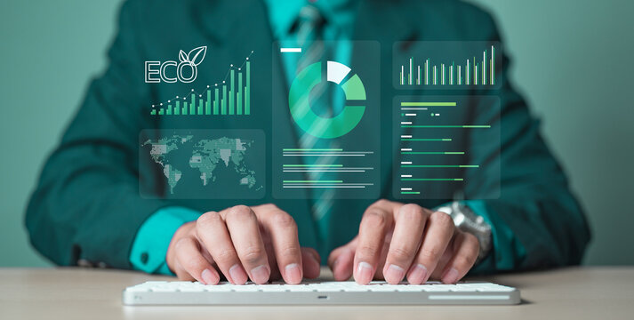 A businessman typing on a keyboard with eco data graphics, symbolizing carbon footprint tracking, green sustainability, carbon credits, and climate change awareness in modern environmental business.
