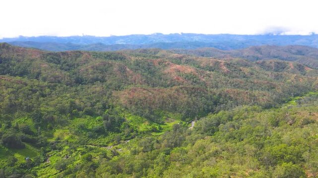 The rugged, diverse highlands of Aileu, Timor-Leste, seen from above. An aerial view shows the varied vegetation, contours, and dry areas of this remote mountain landscape