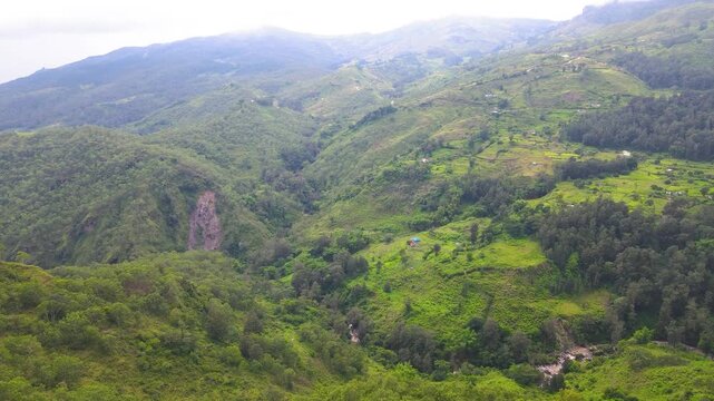 The rugged, diverse highlands of Aileu, Timor-Leste, seen from above. An aerial view shows the varied vegetation, contours, and dry areas of this remote mountain landscape