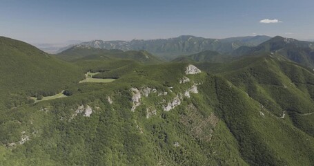 Aerial view of the lush green mountains of Mount Terminio, a landscape where shadows and light dance across the rugged terrain, Mount Terminio, Sala, Italy.