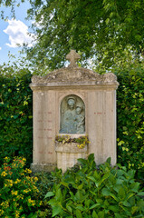 schöner alter Grabstein mit eingebautem Blumenkasten und der Darstellung von Maria mit dem Kind auf einem Friedhof in Rosenheim  © Blende8