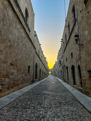 A charming narrow street illuminated at sunset, showcasing beautiful historic architecture