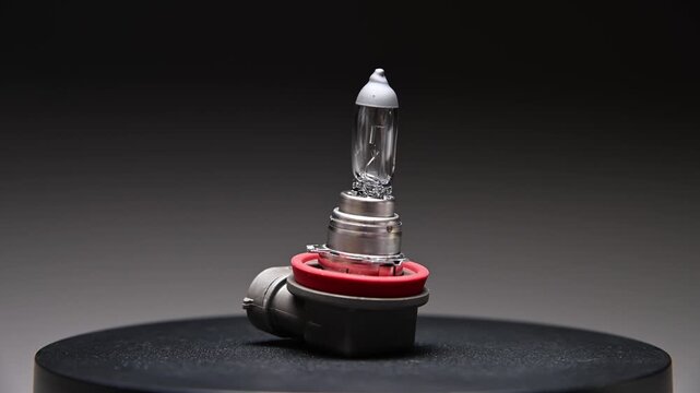 A new spare part rotates on a black gradient background. A car light bulb.