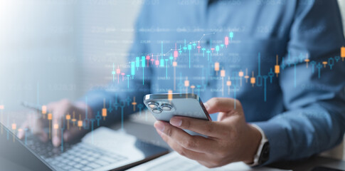 A person analyzing investment data on a smartphone and laptop with stock charts overlayed,...
