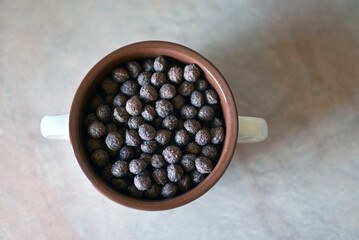 A bowl of chocolate balls for breakfast on a white background