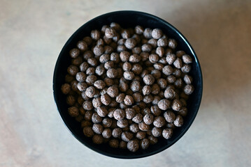 A bowl of chocolate balls for breakfast on a white background