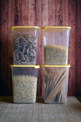 Containers for cereals with pasta, bulgur, rice on a wooden background
