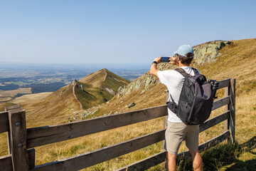 A tourist taking a picture of the Super-Besse landscape with his smartphone