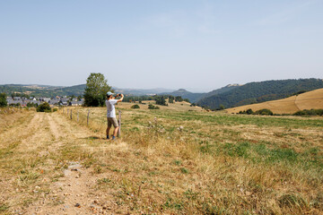 A tourist taking a photo in the countryside of Besse-et-Saint-Anastaise, France