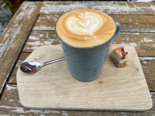 delicious coffee latte on a wooden board, spoon
