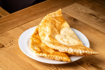 Golden fried chebureki on white plate