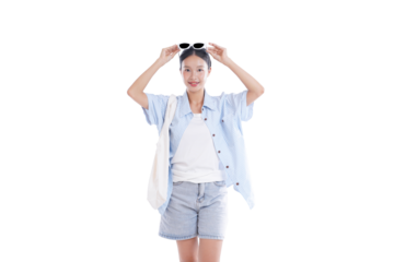 Summer style: A young woman in casual summer attire. She holds sunglasses and wears a light blue button-down shirt and denim shorts, carrying a canvas tote bag. Her expression is joyful and relaxed.