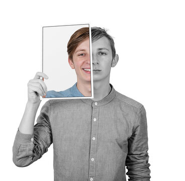Teenage guy covers face with a false portrait sheet to hide his sad feelings. Fatigue adolescent hidden behind a positive emotion paper print. Fake expression mask isolated on transparent background