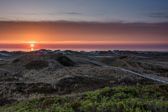Amrum island, Germany: sun rays emerging through the dark storm clouds at the beach of Amrum. 