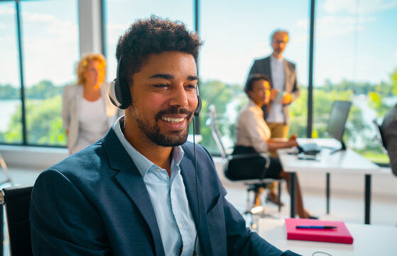 Confident businesswoman smiling while having a phone conversation, using a mobile device in a contemporary high-rise office with a laptop on a glass table - Powered by Adobe
