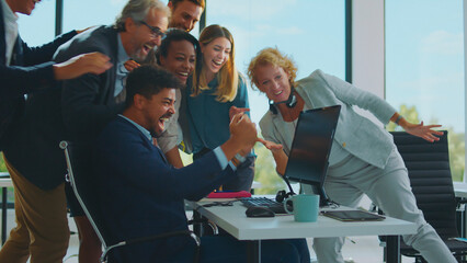 Diverse business team members feeling excited and happy, showing immense joy and high five gestures after achieving business success and celebrating victory in a modern office environment