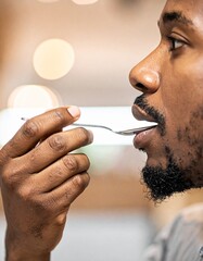 Man tasting with a spoon, close up portrait of african american man tasting with a spoon