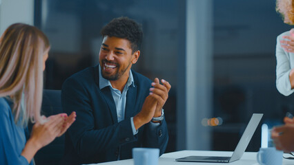 Multiracial business team clapping and smiling in a modern office, celebrating a successful meeting, collaboration and achievement with upbeat, professional energy and teamwork