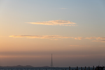 idyllic seascape with pylon and pier during sunset