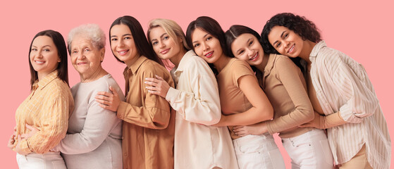 Group of beautiful women hugging on pink background. Women's History Month